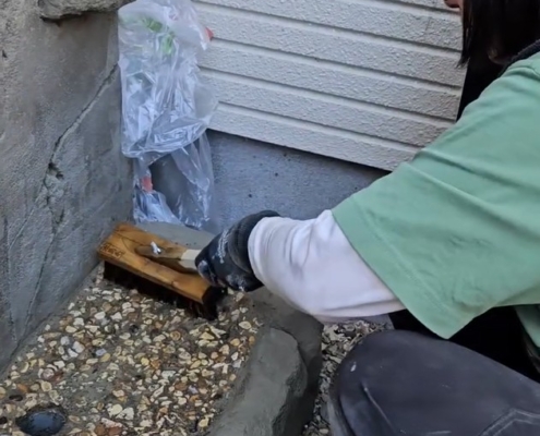 モルタル造形シンクの洗い出し仕上げを行う左官職人の作業風景