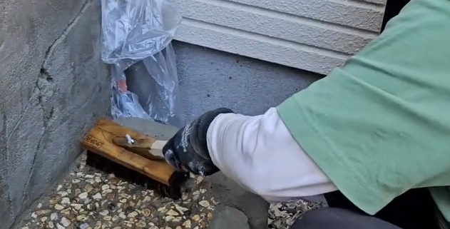 モルタル造形シンクの洗い出し仕上げを行う左官職人の作業風景